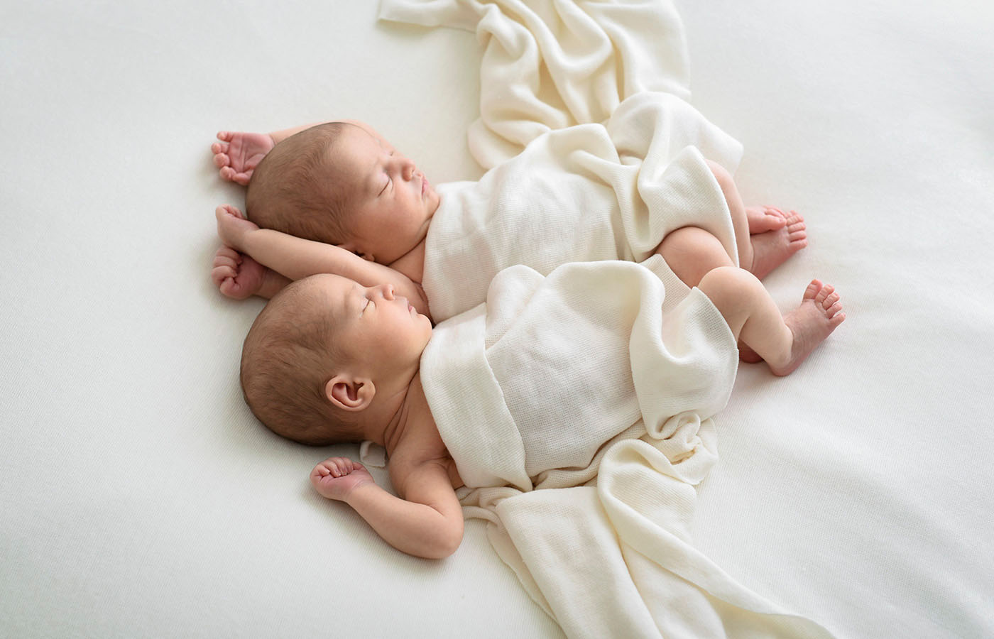 A photograph of twins lying asleep under a blanket taken by Jessica Loren in her studio in Brisbane.